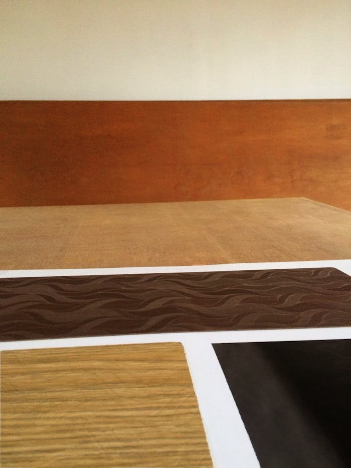 Close-up of various wooden laminate samples showcasing different textures and colors on a wooden table.